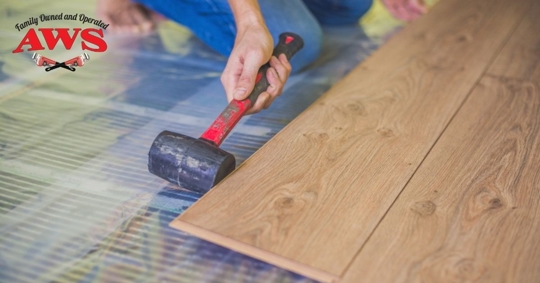 Man hammering floor into place above radiant system